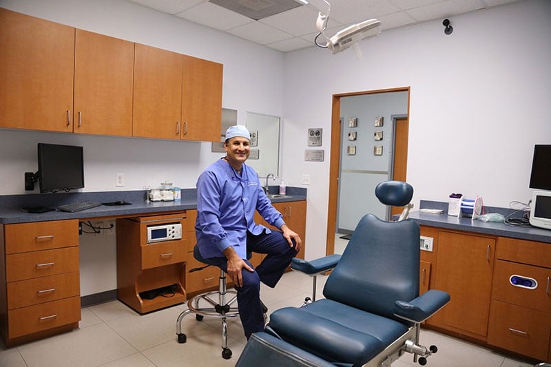 Dr. Carlos Cruz sitting near dentist chair