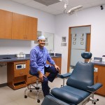 Dr. Carlos Cruz sitting near dentist chair
