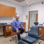 Dr. Carlos Cruz sitting near dentist chair