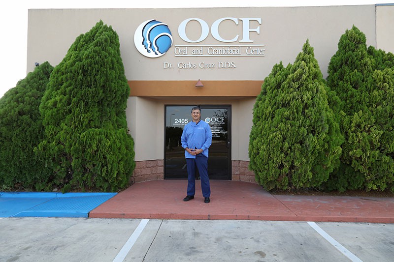 Dr. Carlos Cruz in front of office